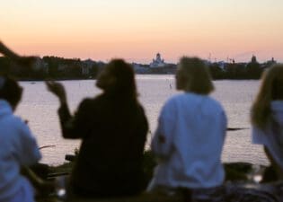 Girls sitting by the sea, Helsinki Cathedral on the background