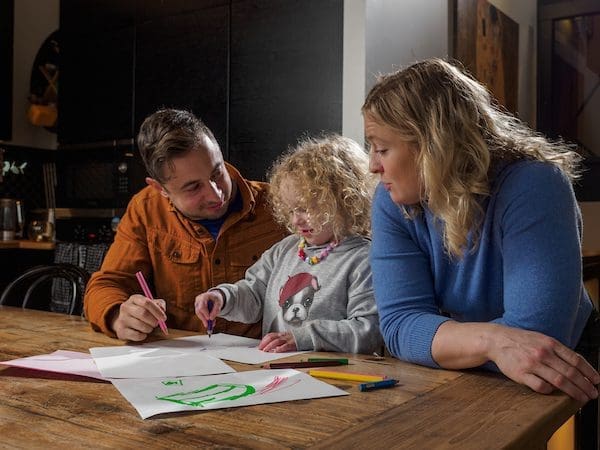 Heini and Miska sitting down with their daughter colouring