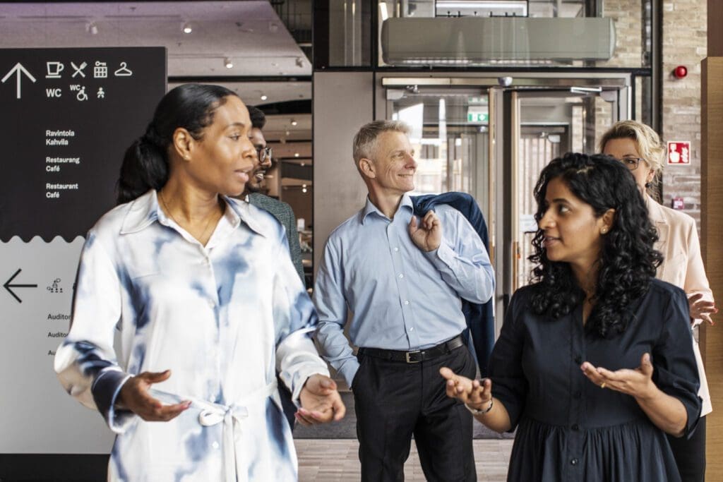 A diverse group of business people walking down a hallway talking