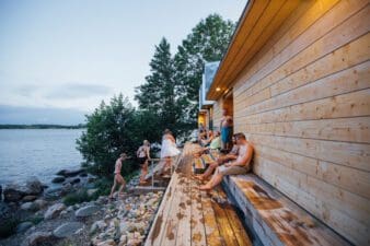 Group of people outside the sauna at Lonna in the summer