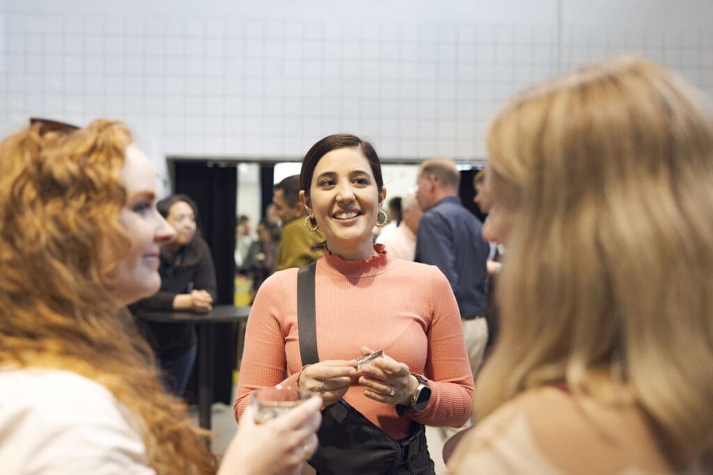 Three women chatting happily at a networking event