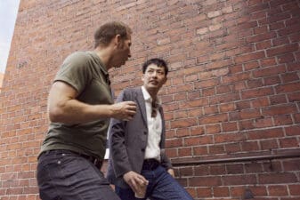 Men walking in front of a red brick building