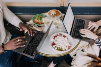 Two people working on their computers over lunch
