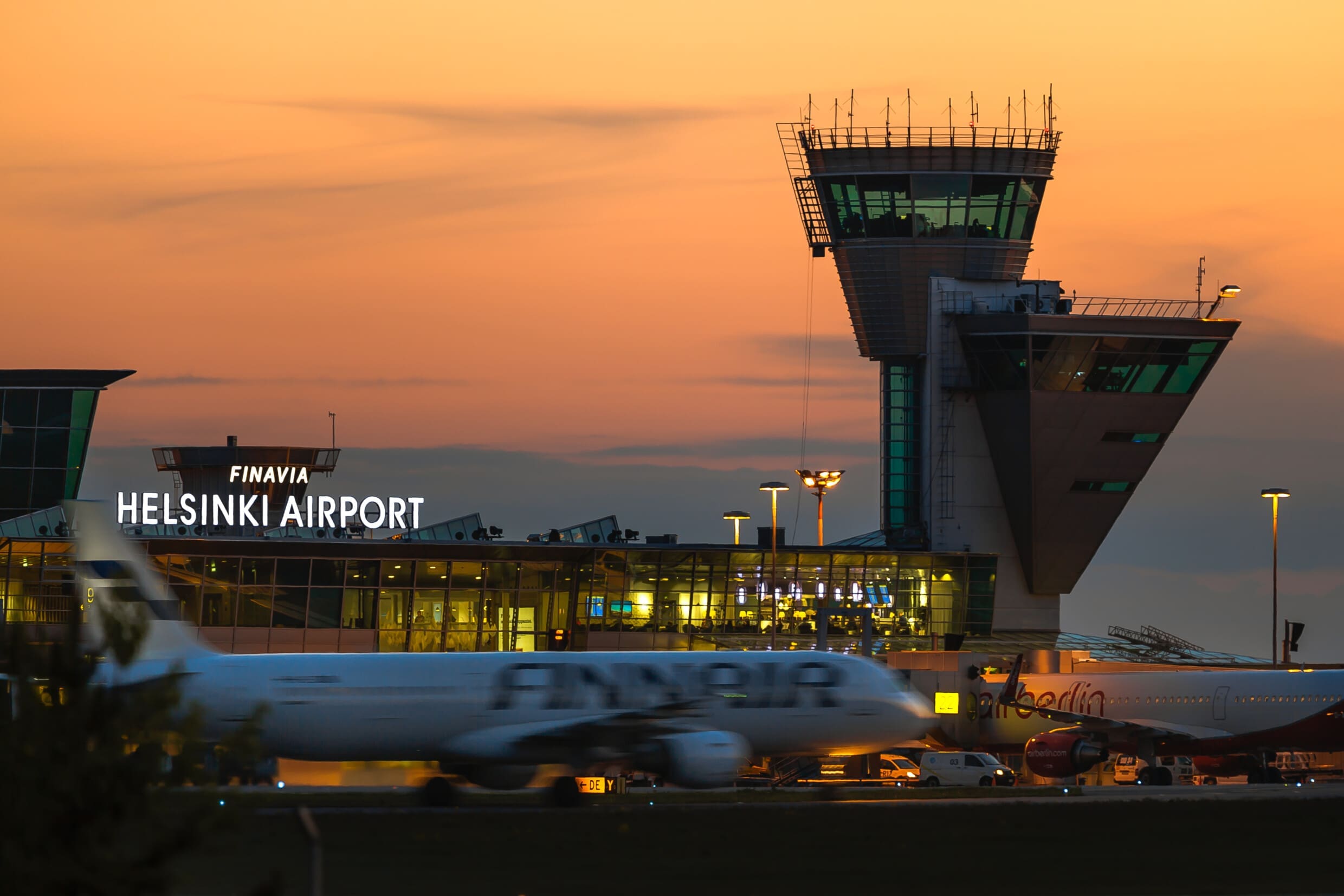 Helsinki airport at sunset behind a Finnair plane