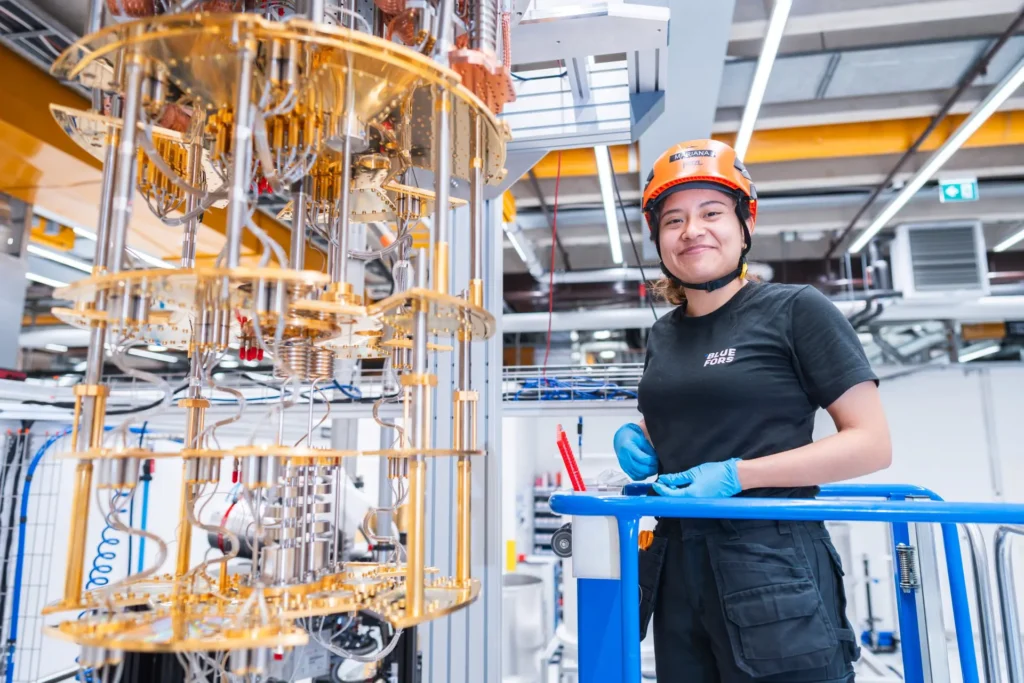 Bluefors worker standing next to a quantum computer