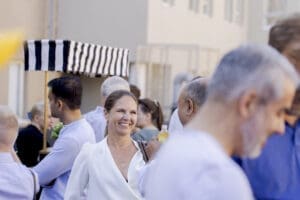 Woman smiling at a crowded outdoor networking event